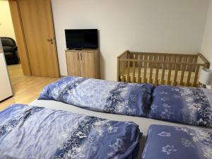 1 dormitorio con 2 almohadas azules y 1 cuna en Ferienwohnung Buchberg, en Neuenbürg