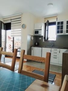 a kitchen with white cabinets and a table and chairs at Reka in Zlatibor