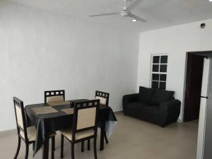 ein Esszimmer mit Tisch und Stühlen und einer Couch in der Unterkunft Casa vacacional Estrella in Cozumel