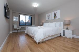 um quarto com uma cama branca e uma janela em Awesome 2 Bedroom Apartment in NYC em Nova Iorque