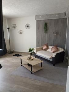 ein Wohnzimmer mit einem Sofa und einem Couchtisch in der Unterkunft Un temps pour soi in Châteauroux
