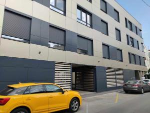 a yellow car parked in front of a building at Apartman Waldy in Osijek +3 photos