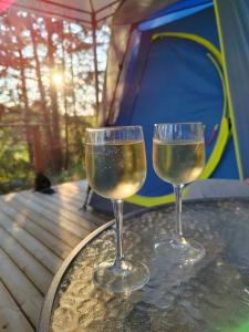 two glasses of wine sitting on a table in front of a tent at Puumaja maaseudulla in Tuorila