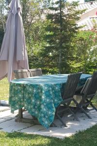 a table with two chairs and an umbrella at La Maison Verte in Tulette