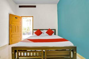 a bedroom with a large bed with red pillows at Flagship Thottunkal Building Thodupuzha in Neriyamangalam
