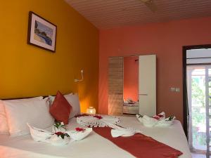 a bedroom with a bed with red and white pillows at Chloe's Cottage Self-Catering in La Digue