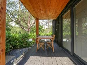 a screened porch with a wooden table on a house at Menai Lodge in Caernarfon