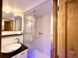 uma casa de banho com um lavatório e uma cabina de duche em vidro. em Luxury Chalet with sauna by Avoriaz Chalets em Avoriaz