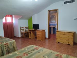 a bedroom with a desk and a bed and a dresser at Hotel Condado de Miranda in Miranda del Castañar