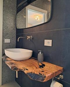 baño con lavabo en una encimera de madera con espejo en Porta San Paolo House, en Castelbuono