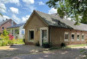 uma casa de tijolos com uma entrada em frente em B&B Het Postkantoortje em Gorssel