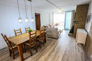 a dining room and living room with a table and chairs at Bello Horizonte ONLY FAMILIES in Salou