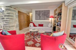 - un salon avec des chaises rouges et un canapé blanc dans l'établissement La Maison de Chagnol classée 5 étoiles, à Rochecolombe