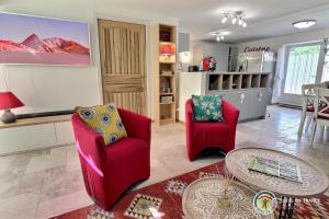 - un salon avec deux chaises rouges et une table dans l'établissement La Maison de Chagnol classée 5 étoiles, à Rochecolombe