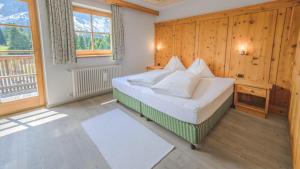 a bedroom with a bed in a room with wooden walls at Ütia De Börz in San Martino in Badia