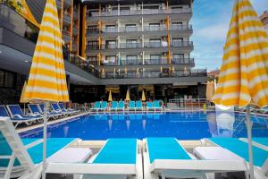 een zwembad met ligstoelen en een hotel bij Arsi Hotel in Alanya
