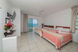 a bedroom with two beds and a view of the ocean at Hotel La Trigueña in Isla Mujeres