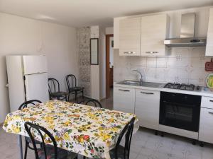 a kitchen with a table with a flowered table cloth at Rivabella Economy 2 in Gallipoli