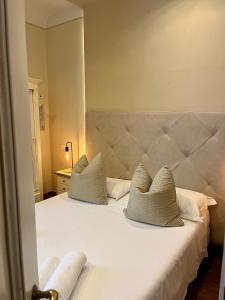 a bedroom with a white bed with two pillows at Soggiorno Pezzati in Florence