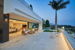 a house with a patio with a palm tree at Sea Gardens Villa in Nerja