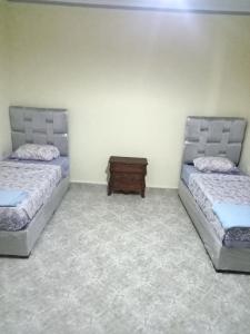 a room with two beds and a table in it at Villa sidi Bouzid in El Jadida