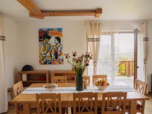 a dining room with a table with a vase of flowers at Wideta in Smerek