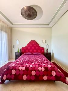 a bedroom with a red bed with a red bedspread at Dar Marrakech in Marrakech