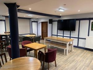 a room with tables and chairs and a flat screen tv at The Bull Hotel in Valley