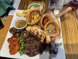 a plate of food with steak and onion rings and fries at The Bull Hotel in Valley