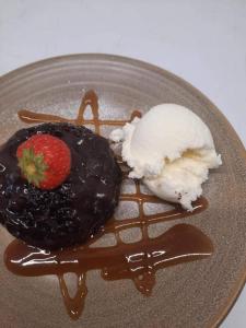 a plate with a chocolate dessert with a strawberry and ice cream at The Bull Hotel in Valley