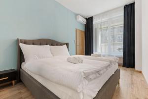 a large white bed in a room with a window at LAM Mint w AC & balcony in Bratislava