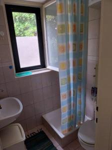 a bathroom with a sink and a toilet and a window at Whole house Ariela, 20m to the beach, has a barbecue, 2 terraces in Šibenik