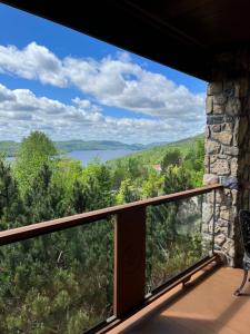 a balcony of a house with a view of a lake at Equinoxe by Rendez-Vous Mont-Tremblant in Mont-Tremblant