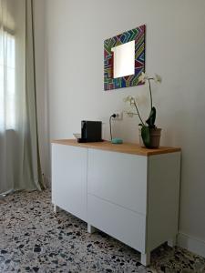 a white dresser with a lamp and a plant on it at Domu Marietta in Pula