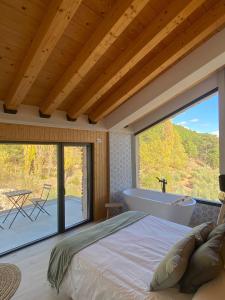 a bedroom with a large window and a tub at Casa Rural Piedra de la Torre in Riópar