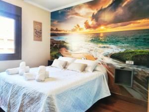 ein Schlafzimmer mit einem Gemälde des Ozeans in der Unterkunft Desconectaengalicia Adosado Vichona a 2,5 km del centro de Sanxenxo in Sanxenxo