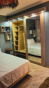 a mirror in a room with two beds and shelves at City Center Van Gogh Suite in Tbilisi City