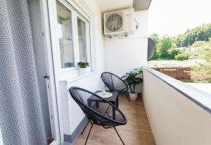 a balcony with two chairs and a table at Lynx and Fox apartment in Delnice