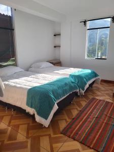 Un dormitorio con una cama con una manta verde. en Vértigo Valle Sagrado, en Urubamba