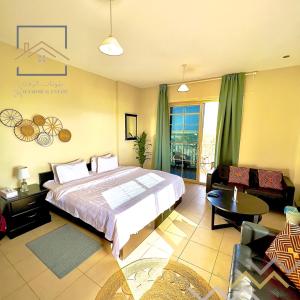 um quarto com uma cama grande e uma sala de estar em بِيُوتات الرفآه - ستوديو بإطلالة بحرية em King Abdullah Economic City