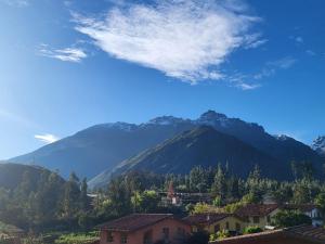 a mountain in the distance with houses and trees at Vertigo Climbing Hostel in Urubamba