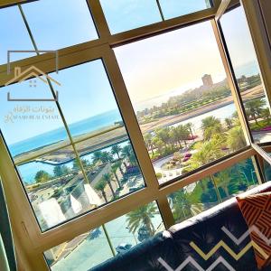 um quarto com vista para a praia a partir de uma janela em بِيُوتات الرفآه - ستوديو بإطلالة بحرية em King Abdullah Economic City