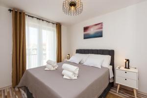 sypialnia z dużym łóżkiem z białymi ręcznikami w obiekcie Apartman Vista Metković w mieście Metković