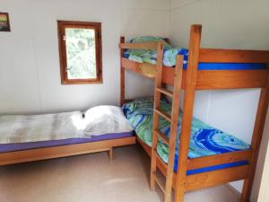 a bedroom with two bunk beds and a ladder at Kemp a Loděnice Podolsko - Chatka pro 3 osoby 