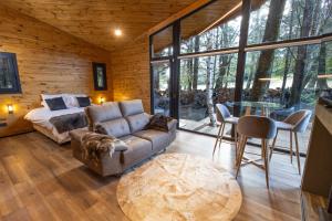 Sala de estar con sofá, cama y mesa en Cabañas Villa Labrador con costa de lago en San Carlos de Bariloche
