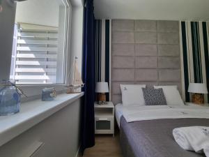 a bedroom with a bed and a window at Apartamenty Marynarskie AP10 in Debina