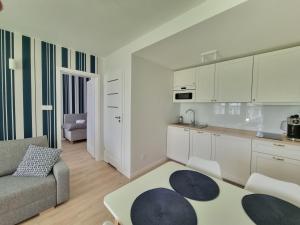 a kitchen and living room with a couch and a table at Apartamenty Marynarskie AP10 in Debina