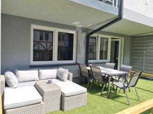 a patio with a couch and a table and chairs at Apartamenty Marynarskie AP10 in Debina