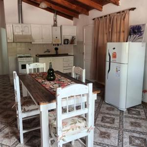 cocina con mesa de madera y nevera en Alojamiento Shanti en Vista Flores