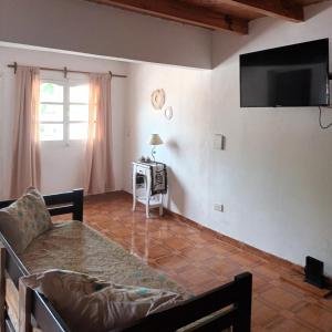 sala de estar con mesa y TV en la pared en Alojamiento Shanti en Vista Flores